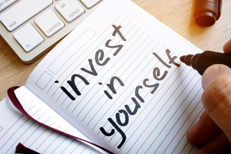 "invest in yourself written on notepad"