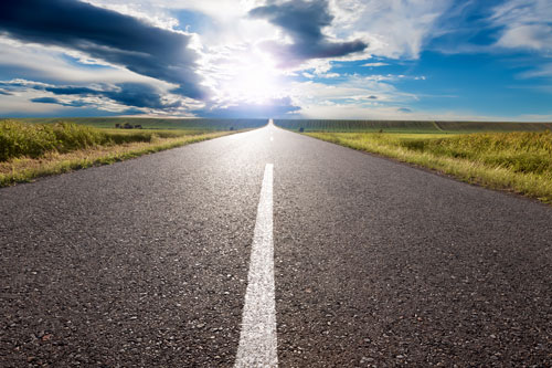 empty road leading to sun near horizon