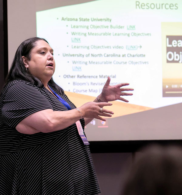 person gesturing toward screen during presentation
